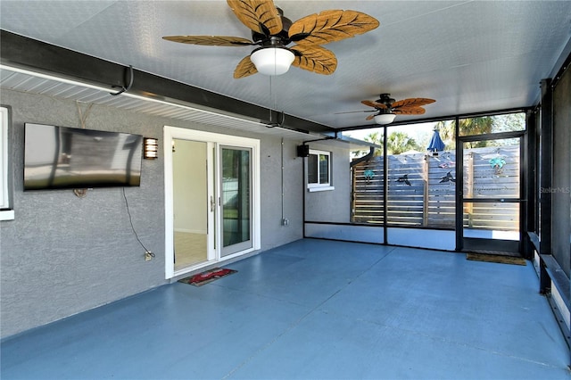 unfurnished sunroom with ceiling fan and beamed ceiling