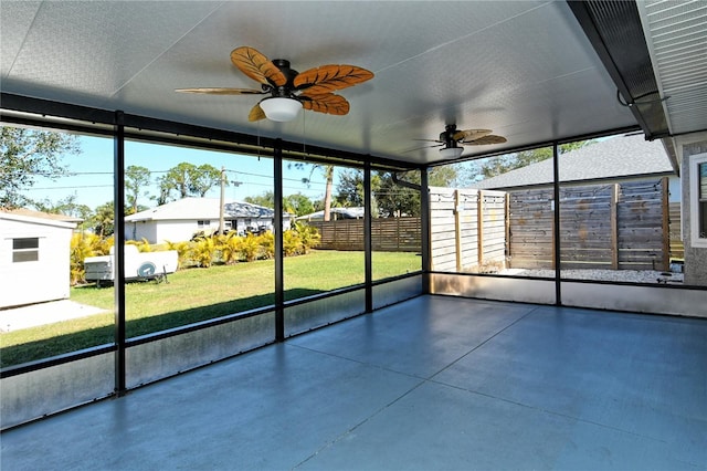 unfurnished sunroom featuring ceiling fan