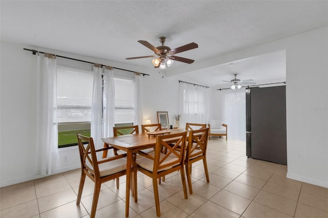 tiled dining space featuring ceiling fan and a textured ceiling