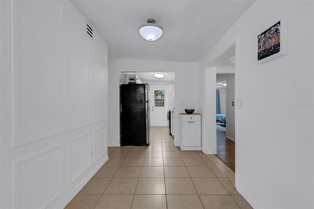 hall with light tile patterned floors