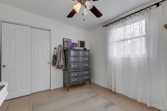 tiled bedroom featuring ceiling fan and a closet