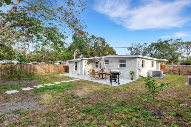 back of property with a patio area, a yard, and central air condition unit