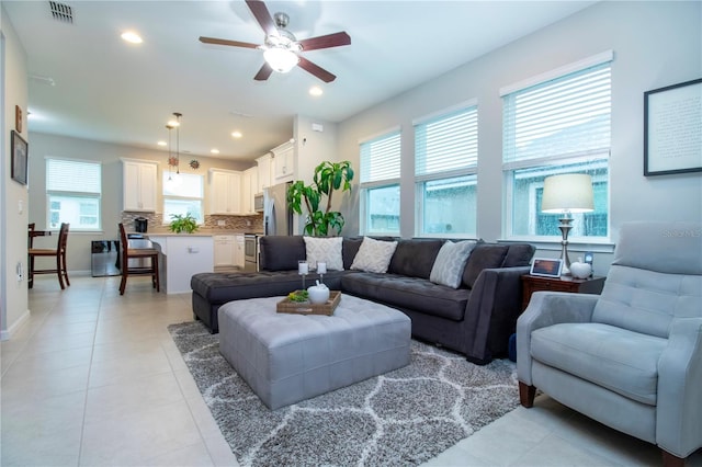 living room featuring light tile patterned floors and ceiling fan