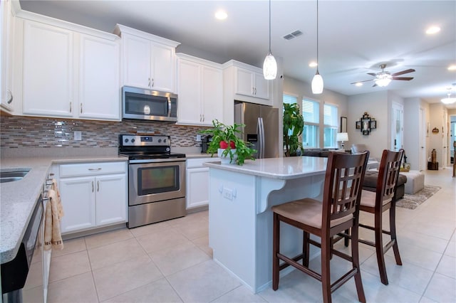 kitchen with stainless steel appliances, white cabinetry, and a kitchen island