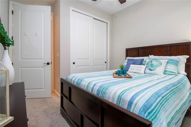 bedroom with ceiling fan, a closet, and light carpet