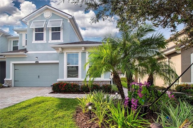 11728 Meadowgate Pl, Bradenton, FL 34211 - view of front facade featuring stucco siding, an attached garage, decorative driveway, and stone siding