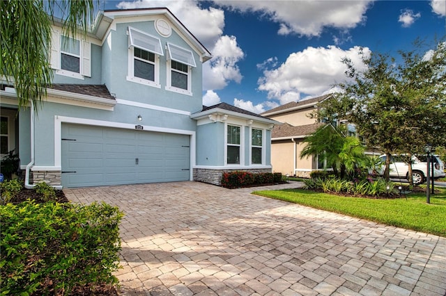 11728 Meadowgate Pl, Bradenton, FL 34211 - view of front of property featuring stone siding, stucco siding, an attached garage, and decorative driveway