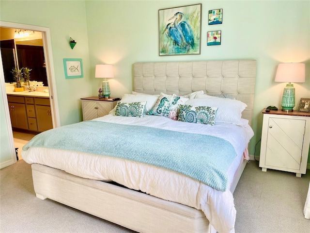 bedroom with connected bathroom and light colored carpet