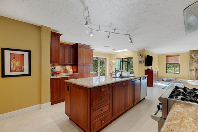 kitchen featuring sink, plenty of natural light, stainless steel dishwasher, and an island with sink