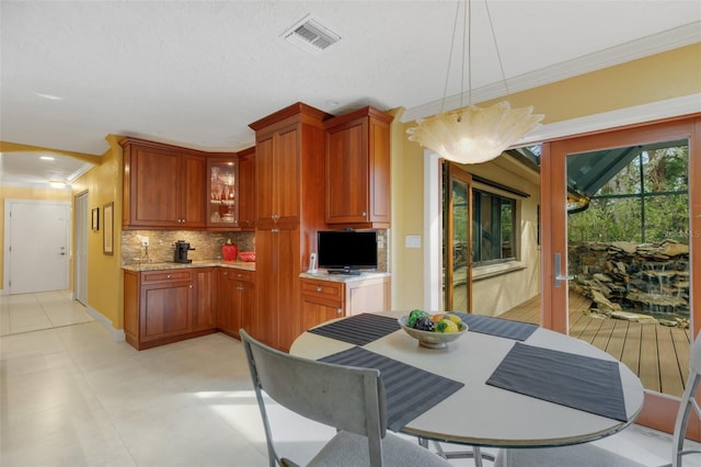 kitchen featuring crown molding, decorative light fixtures, and decorative backsplash