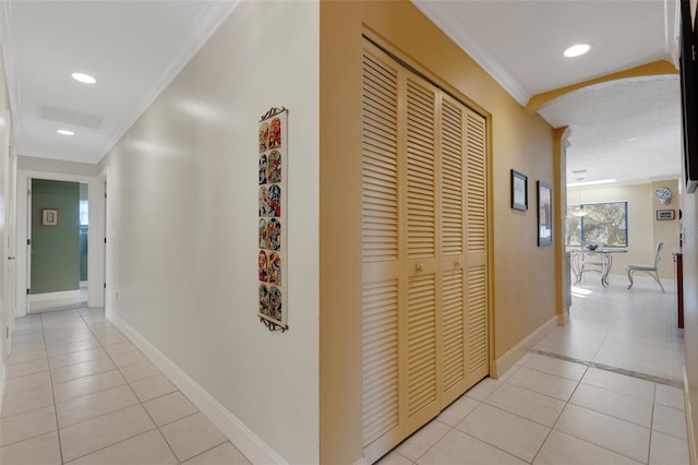 hallway with crown molding and light tile patterned floors