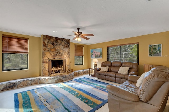 living room with tile patterned floors, a fireplace, ornamental molding, and ceiling fan