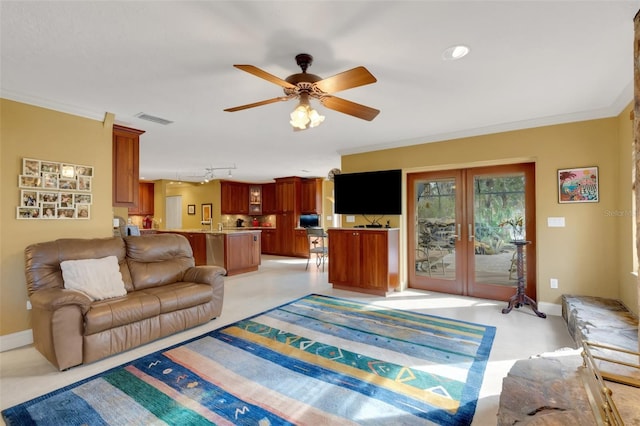 living room with crown molding, rail lighting, ceiling fan, and french doors