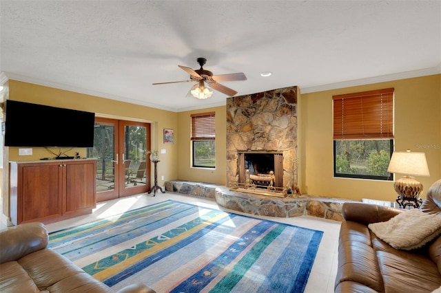 living room with french doors, a fireplace, crown molding, and a textured ceiling