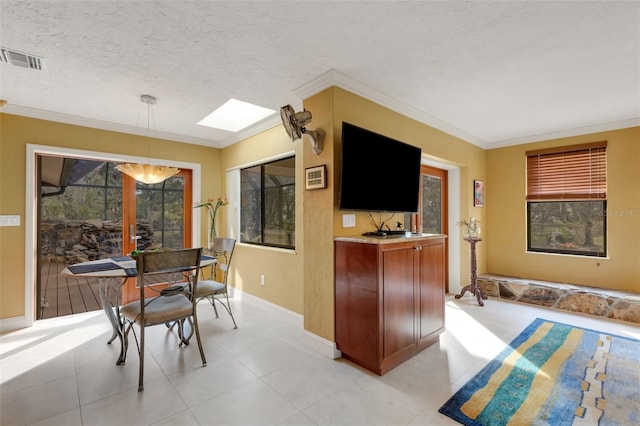 interior space with crown molding, pendant lighting, a textured ceiling, and a skylight