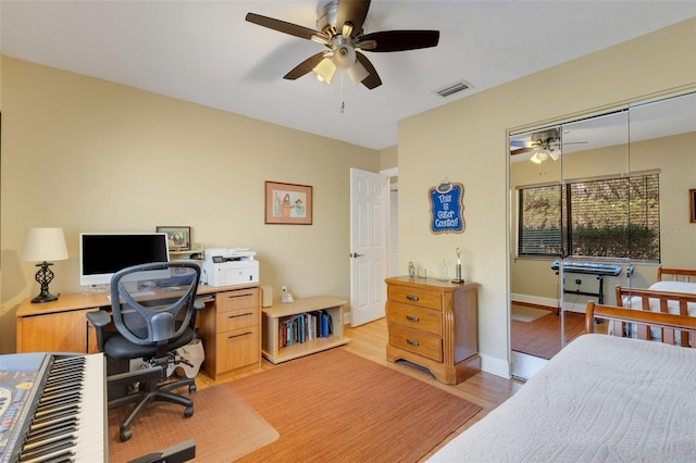 bedroom with light hardwood / wood-style flooring, ceiling fan, and a closet