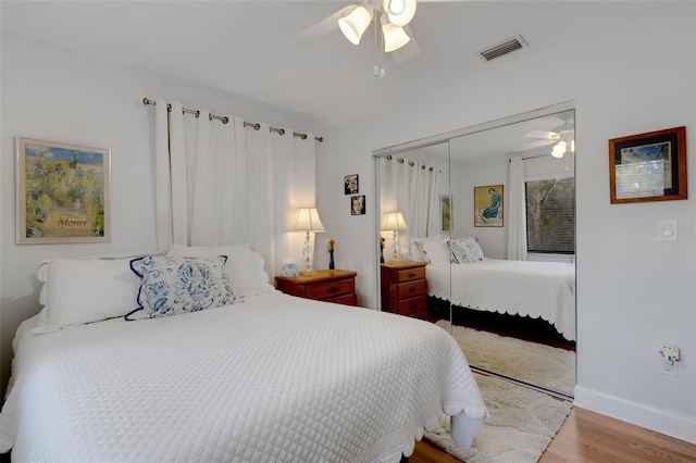 bedroom with ceiling fan, light hardwood / wood-style floors, and a closet