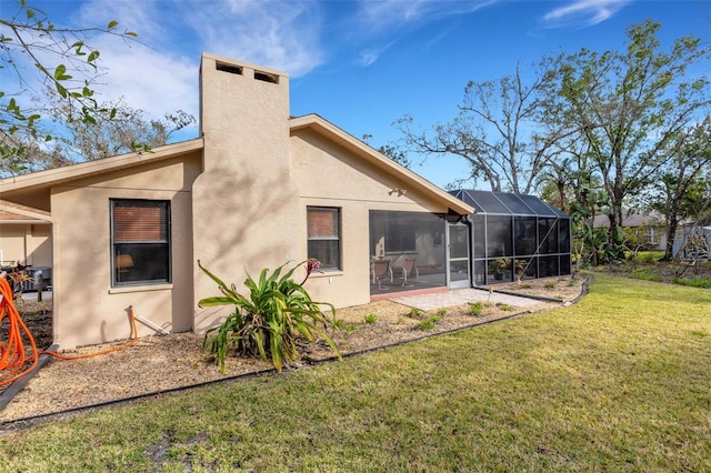 back of house featuring a sunroom, a lanai, and a lawn