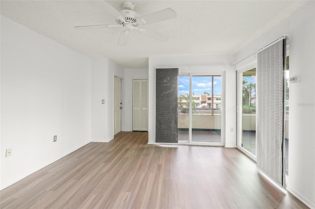 unfurnished room with a textured ceiling, light hardwood / wood-style flooring, and ceiling fan