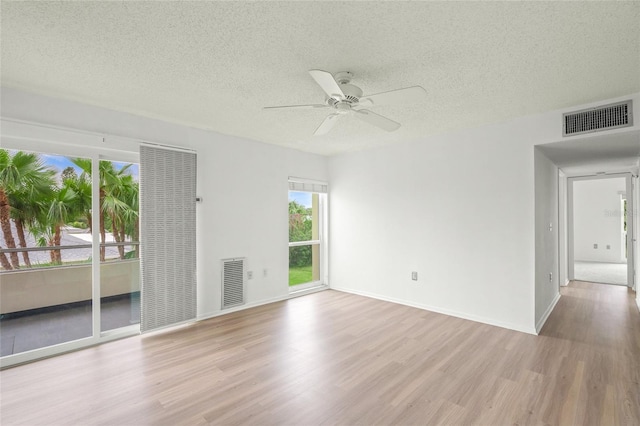 spare room featuring ceiling fan, a textured ceiling, and light wood-type flooring