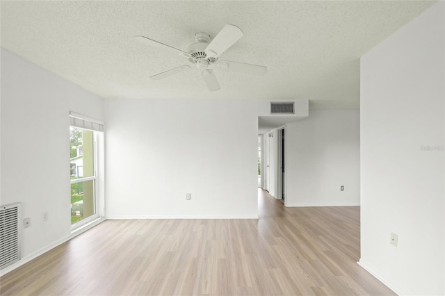 spare room with ceiling fan, a textured ceiling, and light wood-type flooring