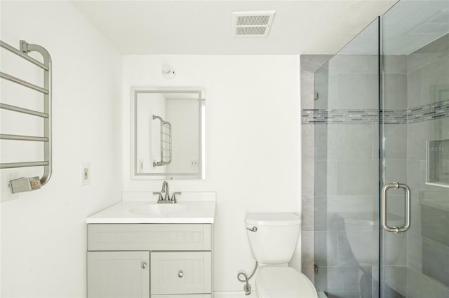 bathroom with vanity, toilet, and an enclosed shower