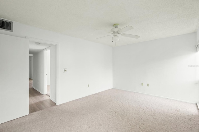 carpeted empty room with a textured ceiling and ceiling fan