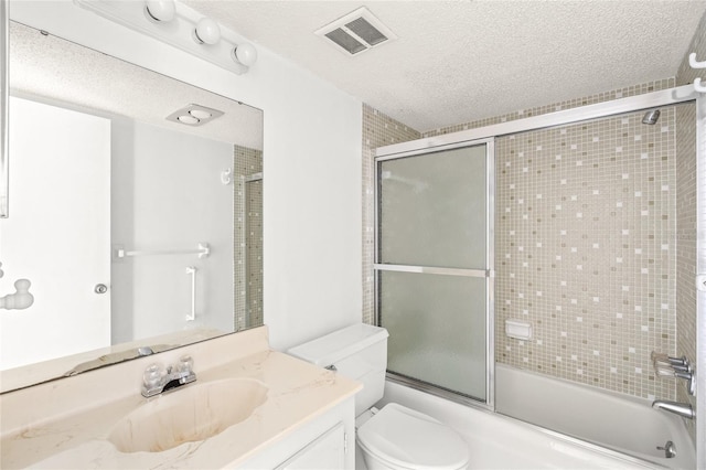 full bathroom featuring a textured ceiling, bath / shower combo with glass door, toilet, and vanity