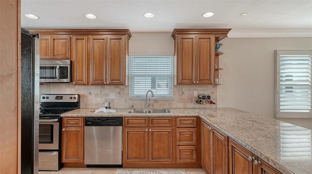 kitchen featuring sink, decorative backsplash, stainless steel appliances, and light stone countertops