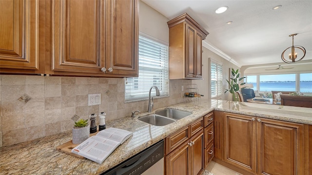 kitchen featuring sink, hanging light fixtures, ornamental molding, light stone countertops, and decorative backsplash