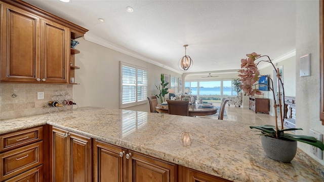 kitchen with light stone counters, brown cabinets, crown molding, open shelves, and backsplash