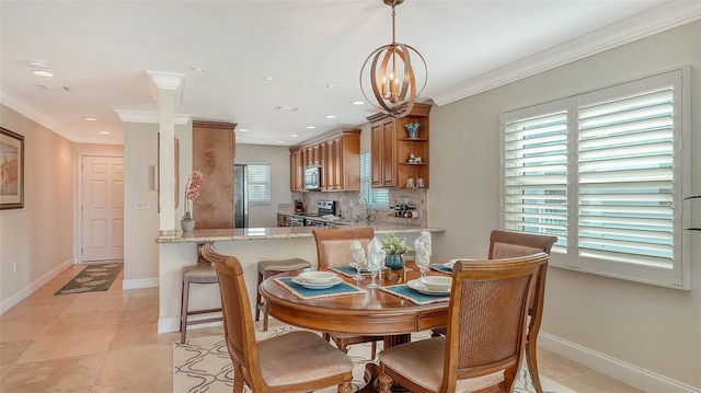 tiled dining room featuring crown molding, a chandelier, and sink