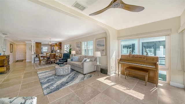 tiled living room with ceiling fan and ornamental molding