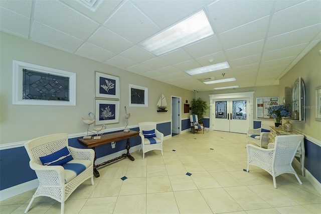 sitting room featuring light tile patterned floors and a drop ceiling