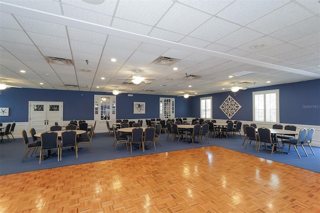 dining room featuring a drop ceiling, parquet flooring, and ceiling fan