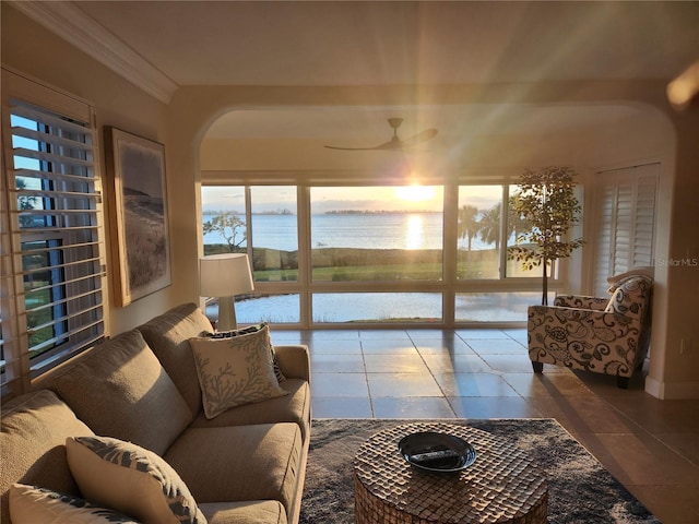 living room with tile patterned flooring, a water view, crown molding, and ceiling fan