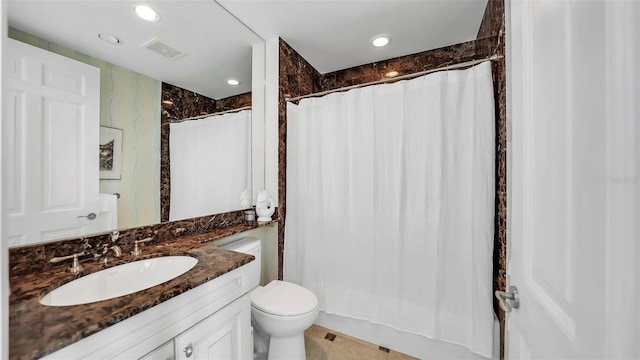 bathroom with toilet, vanity, and a shower with curtain