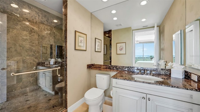 bathroom with toilet, vanity, and a shower with shower door