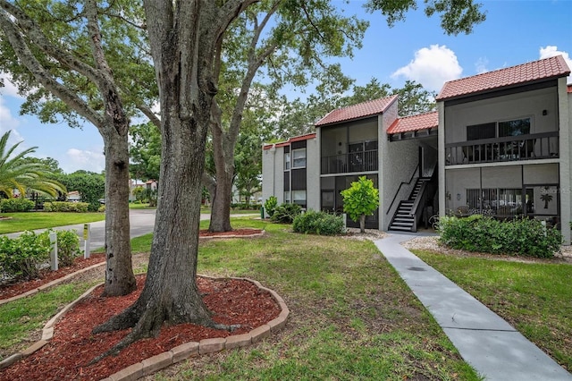 view of community with stairway and a yard