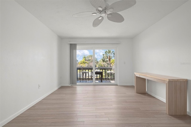 spare room featuring light wood-type flooring, baseboards, and a ceiling fan