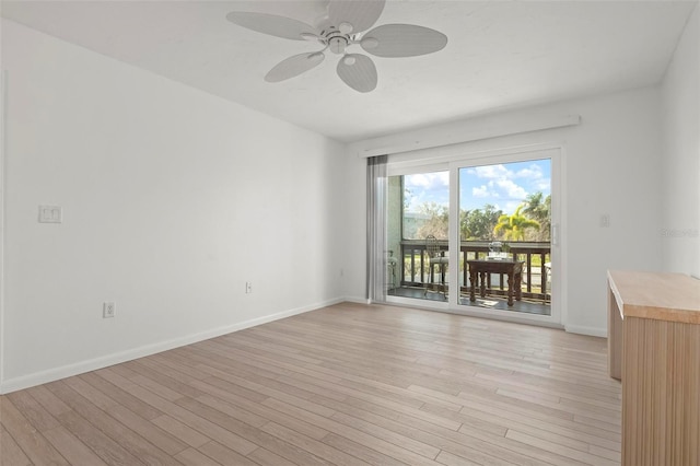 spare room featuring baseboards, a ceiling fan, and light wood-style floors