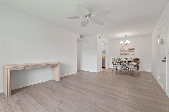 unfurnished dining area featuring baseboards, visible vents, light wood finished floors, and ceiling fan with notable chandelier