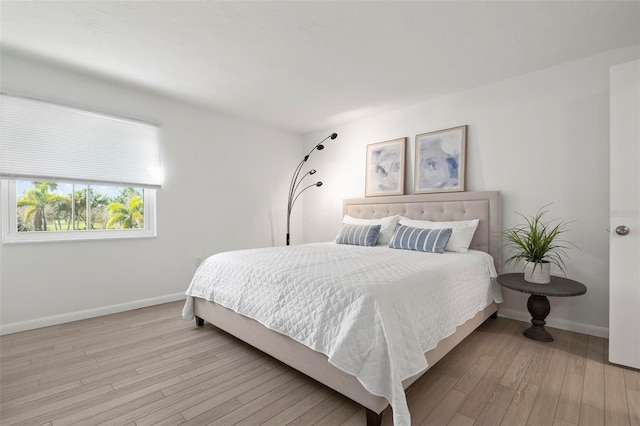 bedroom featuring baseboards and light wood finished floors