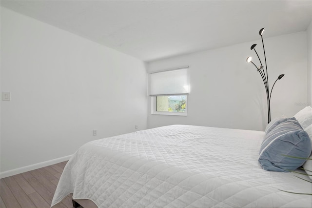 bedroom with light wood-type flooring and baseboards