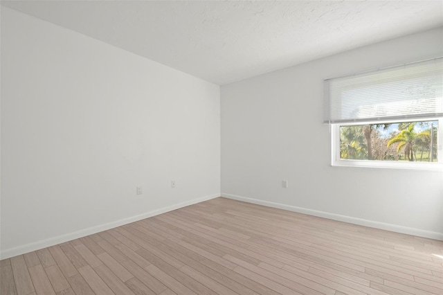 empty room featuring light wood-style flooring and baseboards