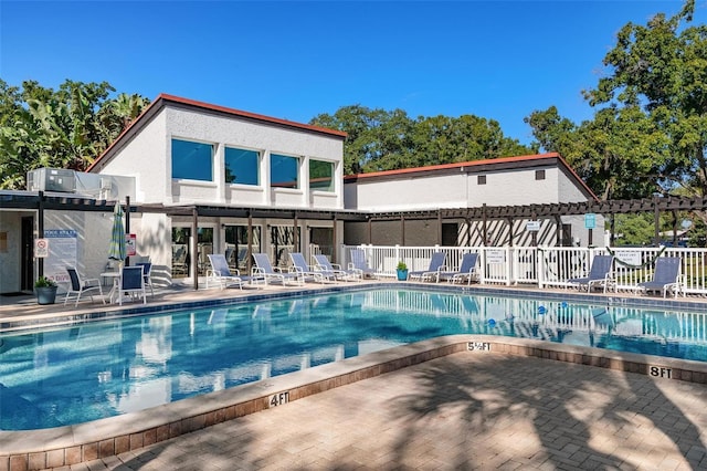 pool with a patio area, fence, and a pergola