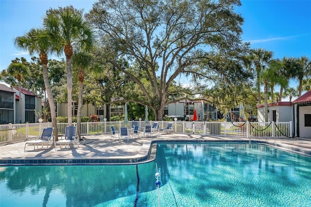 community pool with fence and a patio