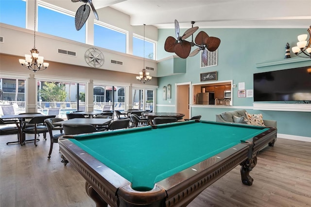 recreation room featuring visible vents, a notable chandelier, baseboards, and wood finished floors