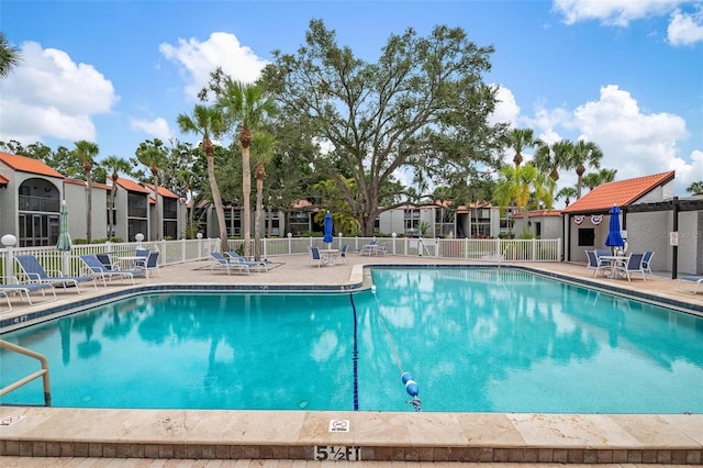 pool featuring a residential view, fence, and a patio