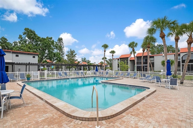 community pool featuring a patio and fence